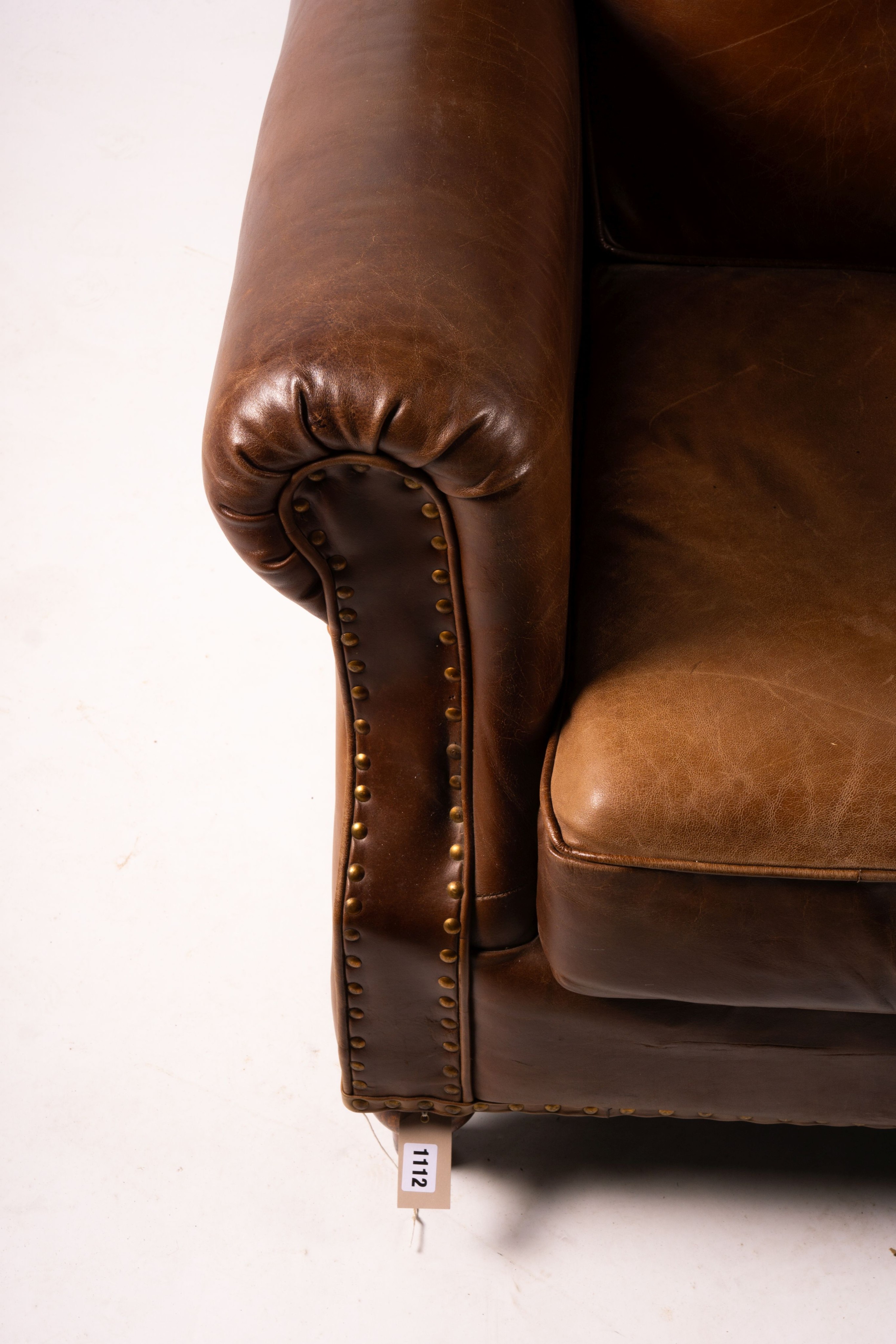 A pair of brown leather club armchairs, width 96cm, depth 80cm, height 90cm